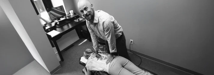 Chiropractor Edina MN David Leske Adjusting Patient Chiropractic Care Dr. David Leske is pictured adjusting a chiropractic patient in black and white