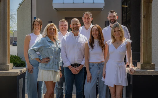 Chiropractor Edina MN Mackenzie Arellanes David Leske Danny Heim and James Anderson with Team Outside a photo of the entire team at Health & Wellness Center Edina smiling and laughing with each other